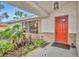 Orange front door entry with brick and plant accents at 817 W 9Th St, Deltona, FL 32725