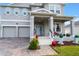 Two-story house with gray siding, two-car garage, and a welcoming front porch at 887 Panical Dr, Apopka, FL 32703