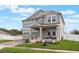 Two-story house with gray siding, two-car garage, covered porch, and landscaped lawn at 887 Panical Dr, Apopka, FL 32703