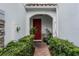 Inviting entryway with red door and a relaxing patio chair at 14493 Swanley St, Orlando, FL 32832