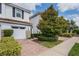 Two-story townhome with white exterior, red door, and landscaped front yard at 14493 Swanley St, Orlando, FL 32832