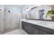 Modern bathroom with double vanity, large mirror, and walk-in shower at 15810 Shorebird Ln, Winter Garden, FL 34787