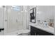 Modern bathroom with a walk-in shower and dark vanity at 15810 Shorebird Ln, Winter Garden, FL 34787