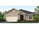 One-story house with light brown siding and a two-car garage at 1723 Three Bars Rd, Kissimmee, FL 34744