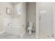 Bathroom featuring white tile, gray floors, a soaking tub and glass shower enclosure at 1875 Staunton Ave, Winter Park, FL 32789