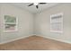 Another angle of the bedroom showcasing wood-look floors and natural light from two windows at 1875 Staunton Ave, Winter Park, FL 32789