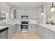 This kitchen boasts gray cabinets, white subway tile backsplash, stainless steel appliances, and wood-look flooring at 1875 Staunton Ave, Winter Park, FL 32789