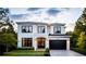 Elegant two-story home featuring a black garage door, black trim, and manicured lawn at 2011 University Dr, Orlando, FL 32804