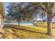 Spacious backyard with lush grass, mature trees, and a lake view at 2132 Darlin Cir, Orlando, FL 32820