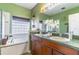Bright bathroom featuring double sinks, vanity, large mirror and tub with window at 2132 Darlin Cir, Orlando, FL 32820