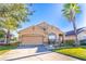 Charming single-story home with a two-car garage and lush landscaping, including a palm tree at 2132 Darlin Cir, Orlando, FL 32820