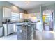 Spacious kitchen with white cabinets, an island with wood paneling, and stainless steel appliances at 2132 Darlin Cir, Orlando, FL 32820