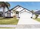 White two-story house with black accents, two-car garage, and palm trees at 2319 Island Club Way, Orlando, FL 32822