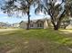 House front showcasing a green exterior and a spacious yard at 3201 S Dorchester Dr, Deltona, FL 32738