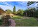 Large backyard with brick pathway, lush lawn, and mature trees at 3817 Bainbridge Ave, Orlando, FL 32839