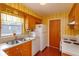 Retro kitchen features wood cabinets, tiled floor, and a vintage refrigerator at 3817 Bainbridge Ave, Orlando, FL 32839