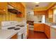 Open kitchen with wood cabinets, view into living room, and vintage stove at 3817 Bainbridge Ave, Orlando, FL 32839