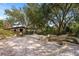 Relaxing stone patio with fire pit, surrounded by lush landscaping and barn at 4230 Rex Dr, Winter Garden, FL 34787