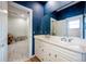 Bathroom with white cabinets and blue patterned wallpaper at 4230 Rex Dr, Winter Garden, FL 34787