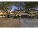 Single-story home with attached garage, illuminated at dusk at 4230 Rex Dr, Winter Garden, FL 34787