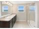 Bathroom with double sinks, granite countertop, and a large shower at 4269 Desert Rose Ave, Kissimmee, FL 34746