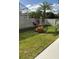 Landscaped backyard with lush green grass, tropical plants, and a white fence at 4726 Combahee Ln, Orlando, FL 32837