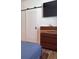 Bedroom with barn door, wood dresser, and large TV at 4726 Combahee Ln, Orlando, FL 32837