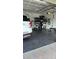 Organized garage with dark-grey tile flooring, storage shelving, and a white SUV at 4726 Combahee Ln, Orlando, FL 32837