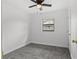 Bedroom with ceiling fan, plush gray carpeting, and a window with a view at 4900 Elese St, Orlando, FL 32811