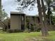 Two-story condo building with wood siding, landscaping, and stairs at 5302 Burning Tree Dr # F-02-2, Orlando, FL 32811