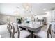 Elegant dining room with a long table, modern lighting, and a view of the kitchen at 7668 Fairfax Dr, Kissimmee, FL 34747