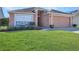 Beige house with a two-car garage and well-manicured lawn at 119 Rockhill Dr, Sanford, FL 32771