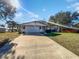 Tan single story home with attached garage and landscaped lawn at 1319 N Old Mill Dr, Deltona, FL 32725