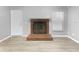 Living room with brick fireplace and wood-look floors at 1350 Bailey Ave, Deltona, FL 32725