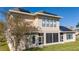 Rear view of a house with solar panels and screened-in patio at 14039 Hampshire Bay Cir, Winter Garden, FL 34787