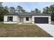 Charming single-story home with a dark gray roof, complemented by an attached two-car garage and a well-manicured lawn at 14735 Sw 69Th Court Rd, Ocala, FL 34473