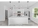 Modern kitchen with white cabinets, large island, and pendant lighting at 162 Nw 42Nd Pl, Ocala, FL 34475