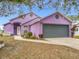 Purple house with gray garage door, landscaping, and walkway at 164 Brad Cir, Winter Haven, FL 33880