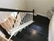 Elegant staircase with black wood stairs and white railings at 1769 White Feather Loop, Oakland, FL 34787