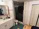 Bathroom featuring a sink, toilet, and walk-in shower with tiled walls at 1960 Pinewood Ln, Mount Dora, FL 32757