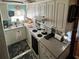 Galley kitchen with white cabinets and appliances at 1960 Pinewood Ln, Mount Dora, FL 32757