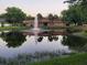 Relax by the pond with a fountain and view of the community center reflecting in the water at 1960 Pinewood Ln, Mount Dora, FL 32757