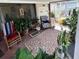 Cozy screened porch with plants, comfortable seating, and a decorative rug, creating a relaxing outdoor space at 1960 Pinewood Ln, Mount Dora, FL 32757
