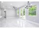 Bright living room with marble floors, modern lighting, and sliding glass doors leading to the outdoor area at 2033 N Orange St, Mount Dora, FL 32757