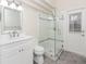 Modern bathroom with white vanity, glass shower, and exterior access at 2077 Wembley Pl, Oviedo, FL 32765