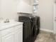 Bright laundry room features washer, dryer, cabinets, and utility sink at 2077 Wembley Pl, Oviedo, FL 32765