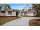 Landscaped yard with curved driveway and a beautiful two-story house with blue front door at 2397 River Tree Cir, Sanford, FL 32771
