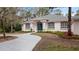 Curved driveway leading to a charming house with blue front door and well-manicured landscaping at 2397 River Tree Cir, Sanford, FL 32771