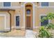 Front entrance with arched entryway and a brown door at 2625 Brompton Ct, Orlando, FL 32833