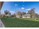 Back yard with lush green grass, various trees, and partial view of houses with solar panels at 264 Wallrock Ct, Ocoee, FL 34761